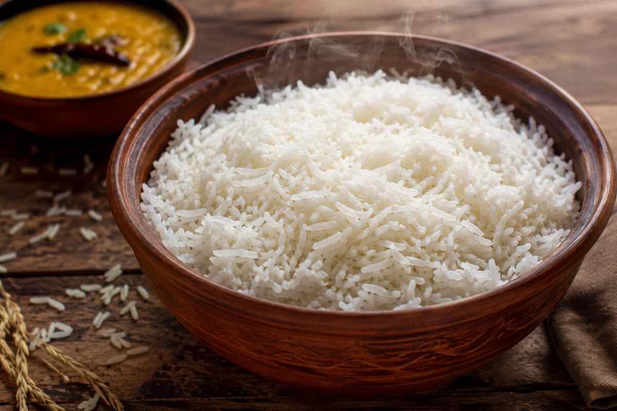 Steaming bowl of banskathi rice with fluffy grains and Bengali dal
